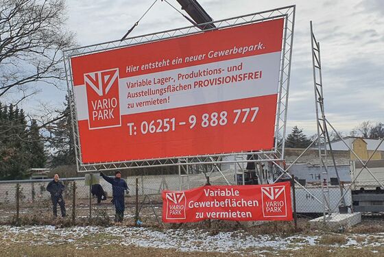 Kran beim Aufbau eines Riesenwerbeschild mit VarioPark-Werbung