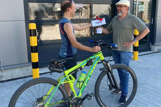Preisgeld mit Weinflasche wird an den Stadtradel-Gewinner übergeben