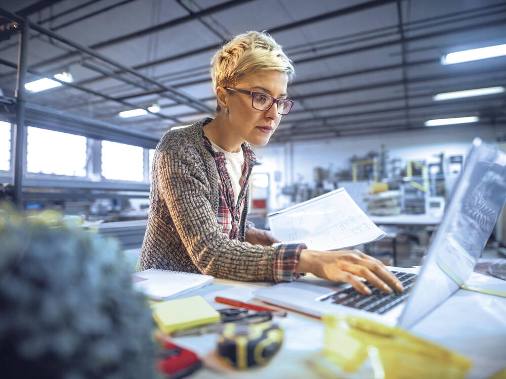 Photo of a VarioPark tenant working at laptop in an industrial surrounding